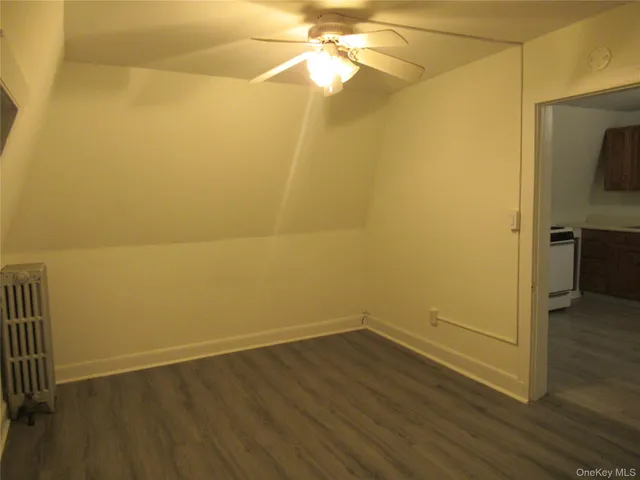 a view of a room with wooden floor and a ceiling fan