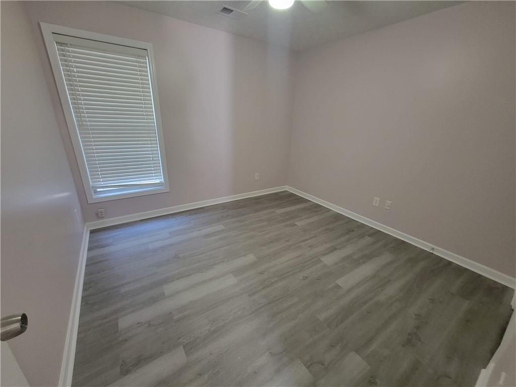 2213 Carlton Chase Road Dacula, GA 30019 - Photo 21 of 30 a view of an empty room with wooden floor and a window