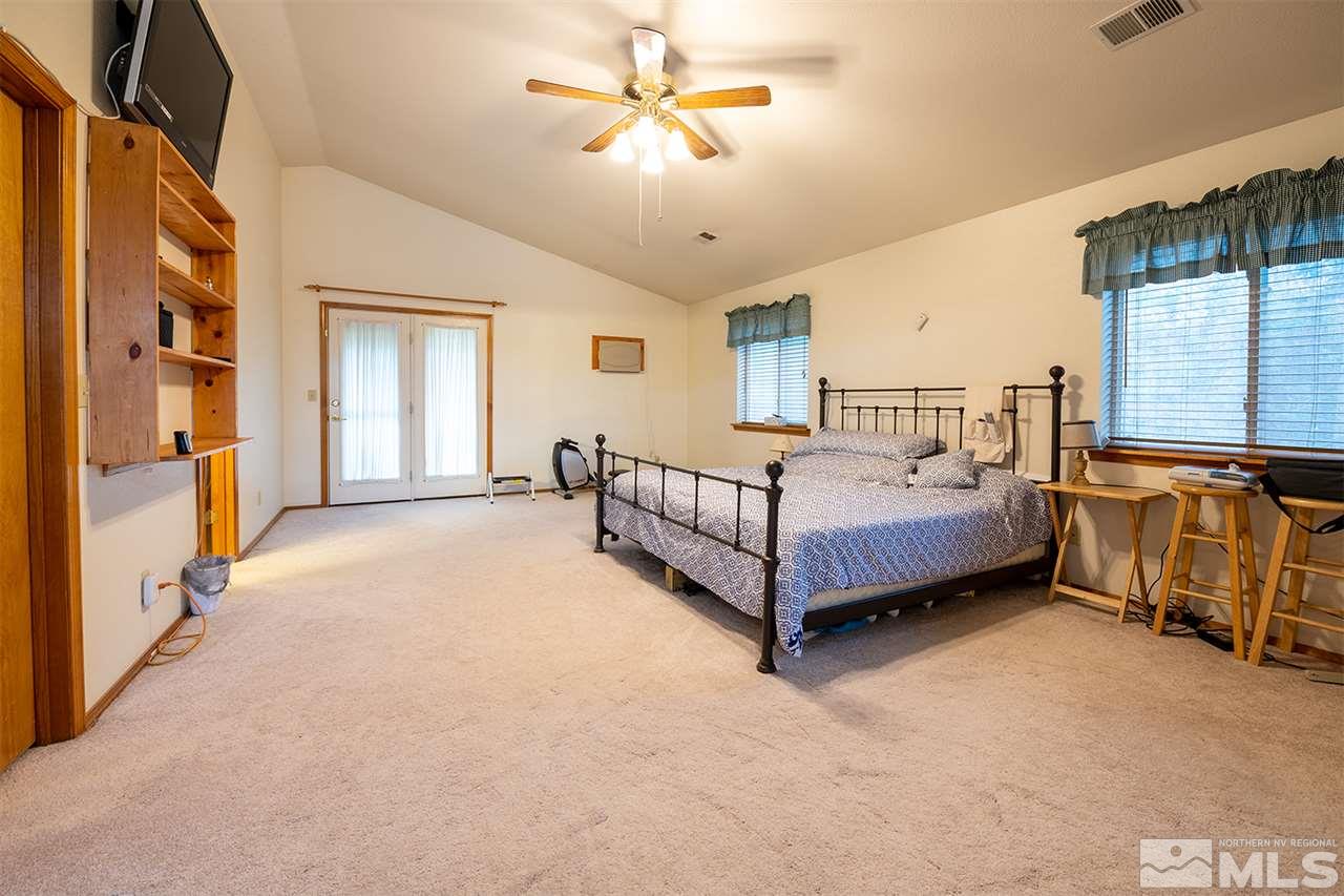 3318 Bottom Road Fallon, NV 89406 - Photo 7 of 23 a spacious bedroom with a bed and a chandelier