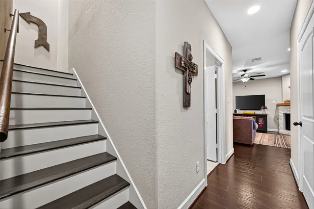 a view of a livingroom with wooden floor and stairs