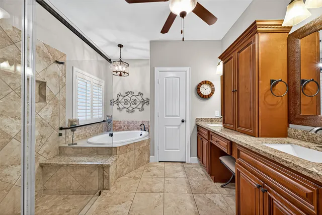 a spacious bathroom with a double vanity sink mirror and bathtub