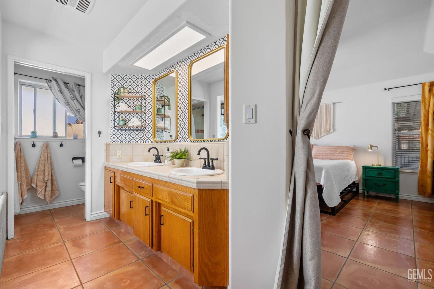 Undisclosed Address Bakersfield, CA 93311 - Photo 44 of 69 a spacious bathroom with a double vanity sink a mirror and a shower