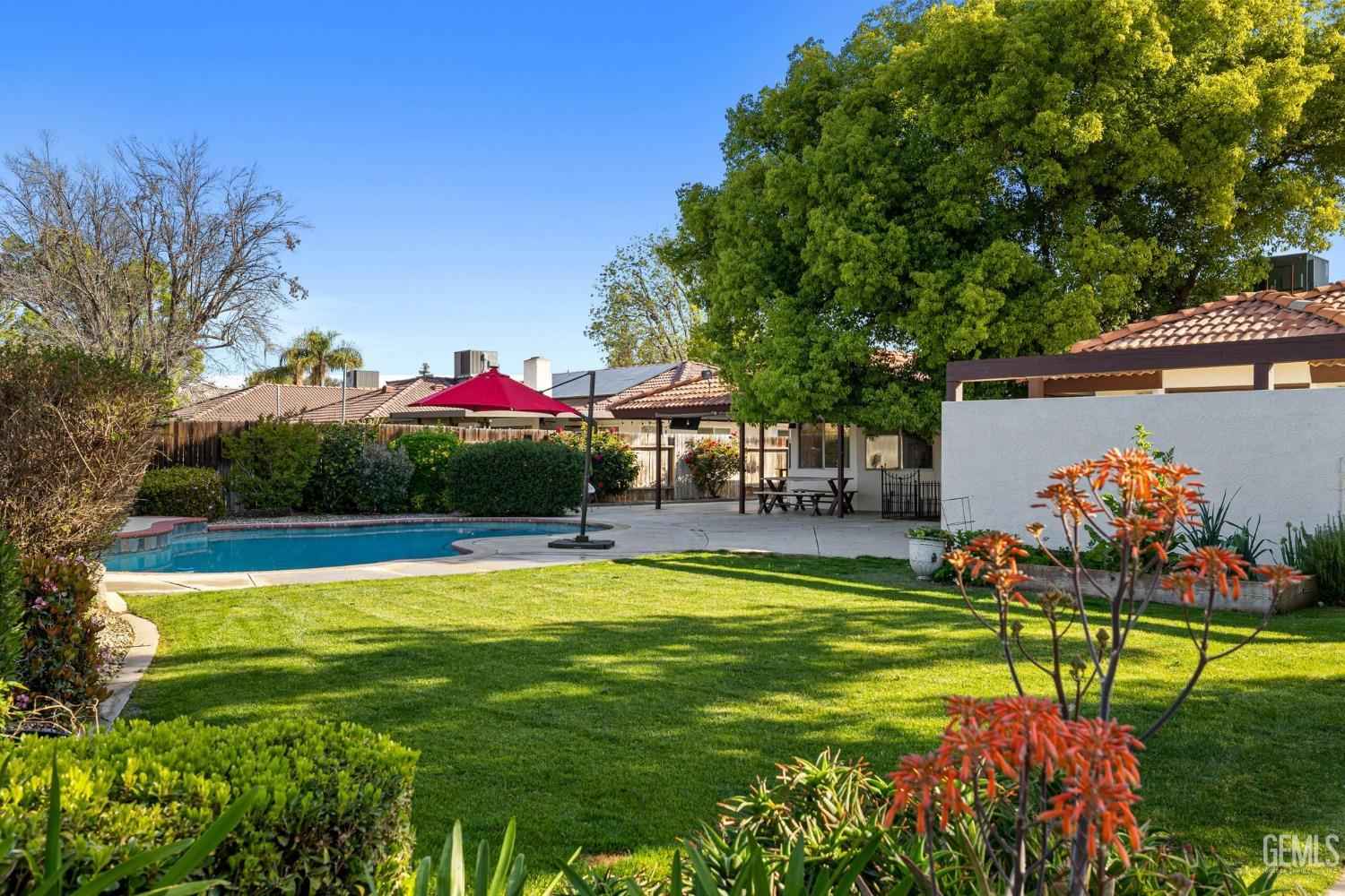 Undisclosed Address Bakersfield, CA 93311 - Photo 56 of 69 a view of a swimming pool with a table and chairs under an umbrella