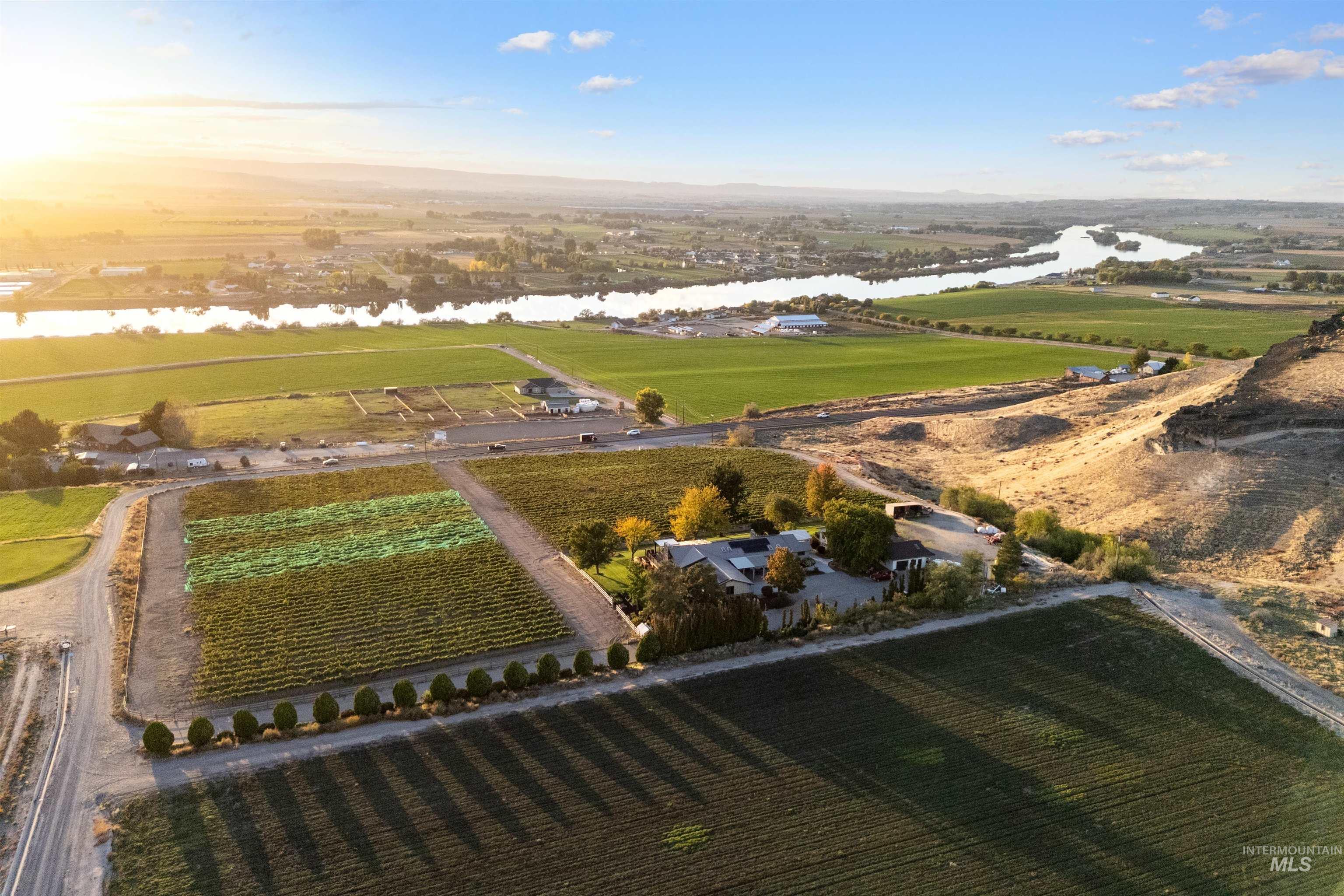 View of rural area with a nearby body of water and large plots for crops