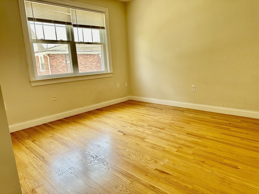 183 Summer Street, Unit 183 Watertown, MA 02472 - Photo 9 of 12 a view of an empty room with wooden floor and a window