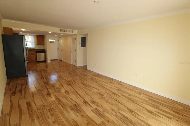 a view of empty room with wooden floor