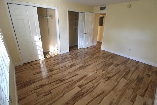 an empty room with wooden floor and entrance