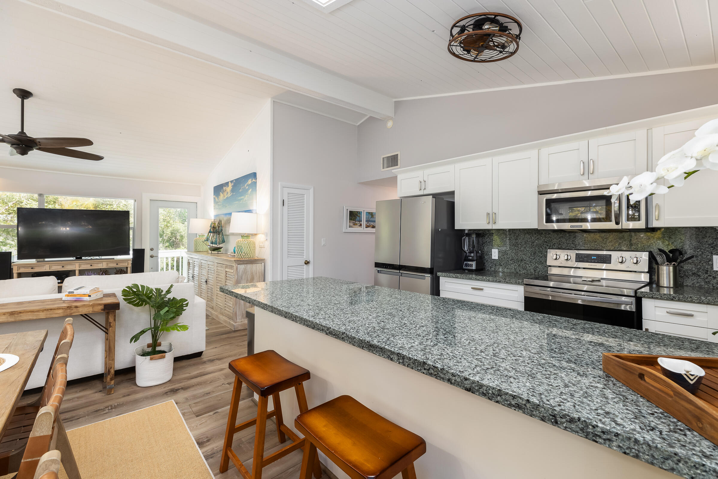 15 Sunset Road Key Largo, FL 33037 - Photo 19 of 58 a kitchen with stainless steel appliances a stove a sink a microwave a refrigerator and chairs