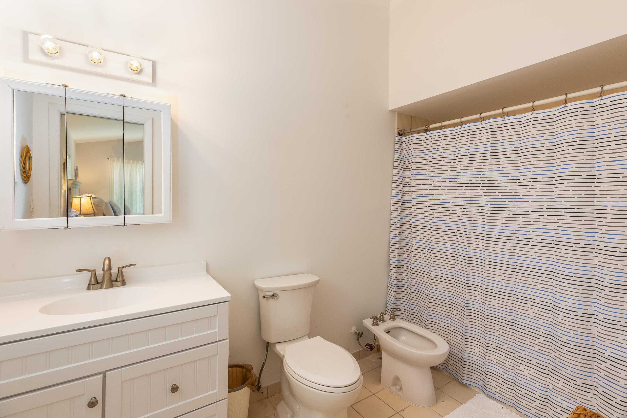 15 Sunset Road Key Largo, FL 33037 - Photo 28 of 58 a bathroom with a granite countertop toilet a sink a mirror and a shower