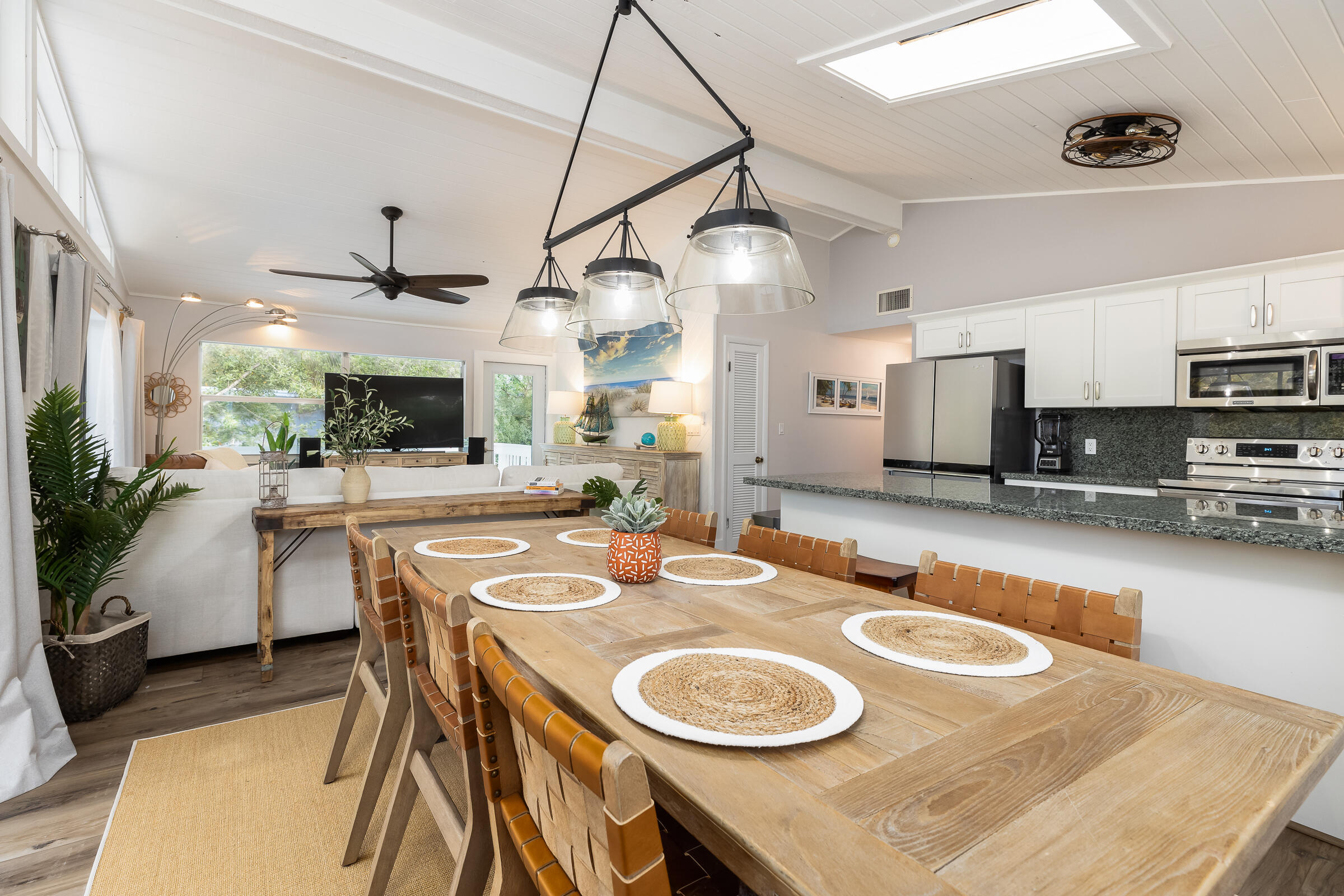 15 Sunset Road Key Largo, FL 33037 - Photo 3 of 58 a kitchen with stainless steel appliances kitchen island granite countertop a sink a stove a dining table and chairs with wooden floor