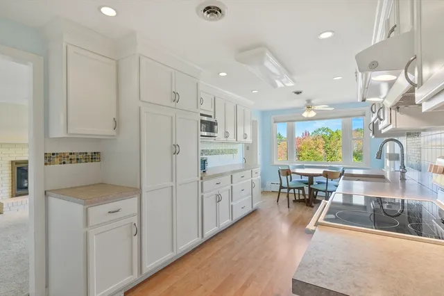 a kitchen with white cabinets and sink
