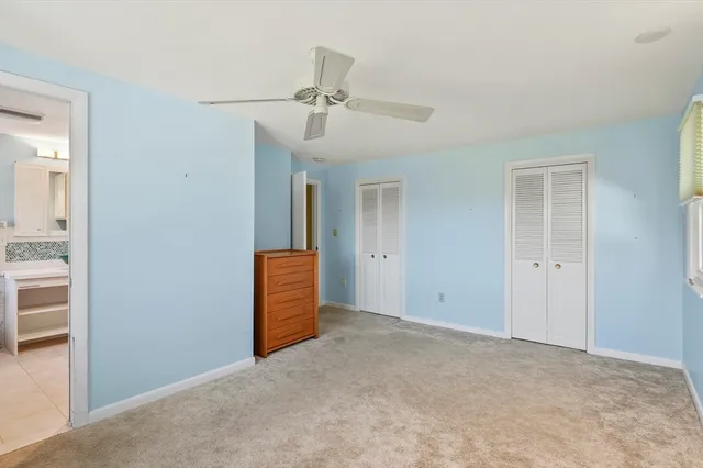 an empty room with closet and a chandelier fan