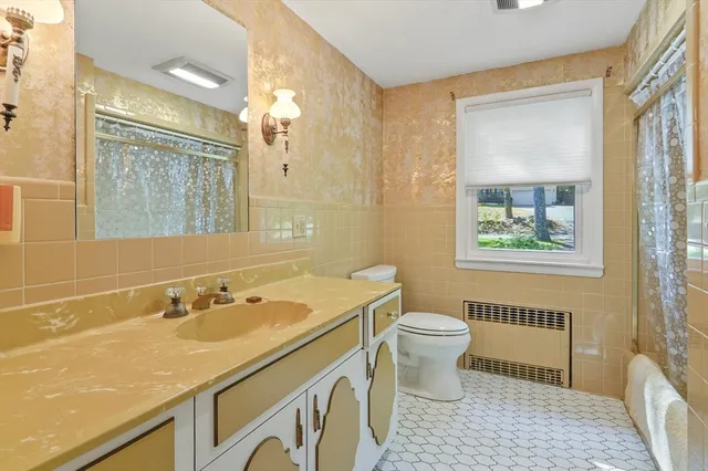 a bathroom with a sink a toilet a mirror and a window