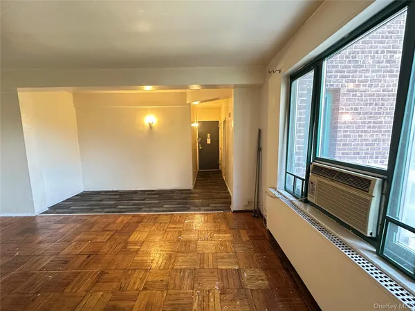 a view of a hallway with wooden floor and a living room