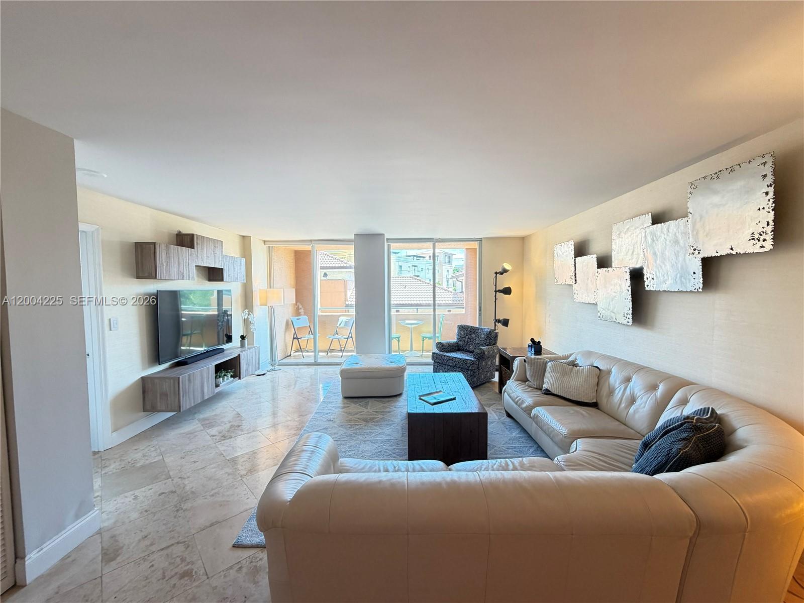 90 Alton Road, Unit 301 Miami Beach, FL 33139 - Photo 2 of 18 a living room with furniture and a flat screen tv