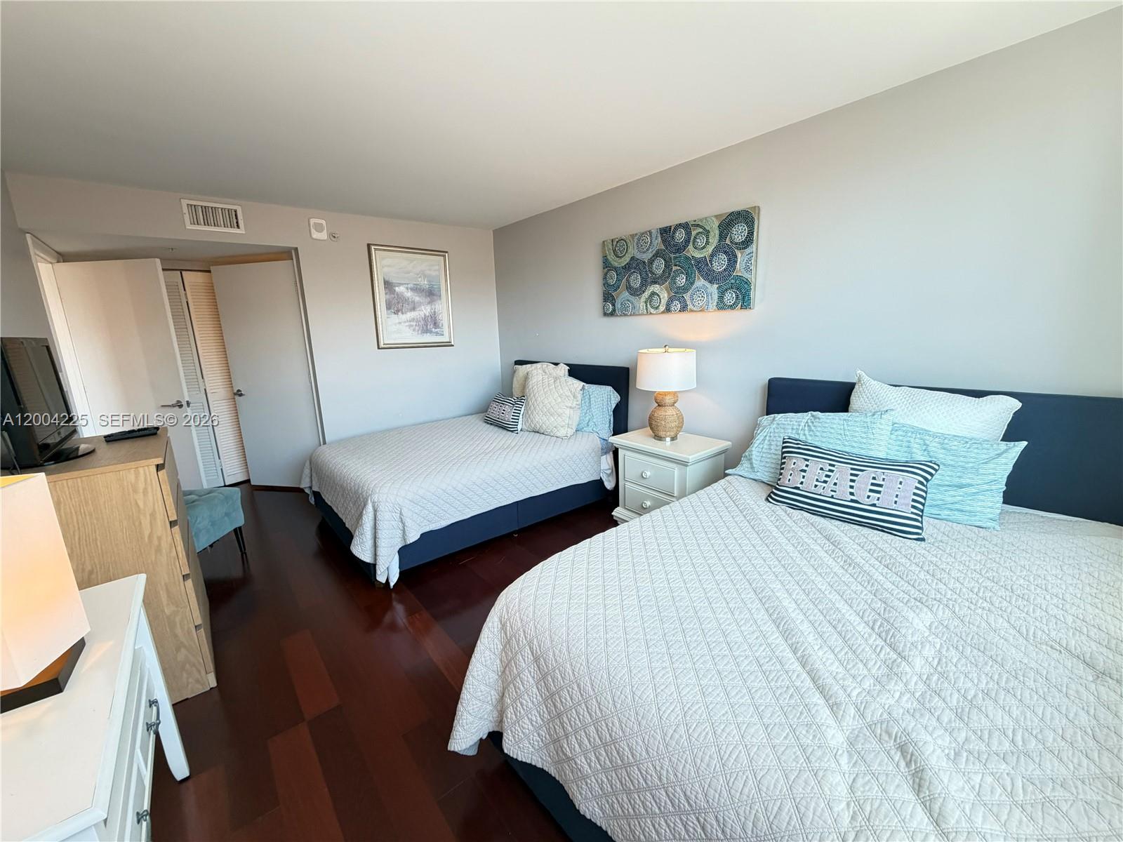 90 Alton Road, Unit 301 Miami Beach, FL 33139 - Photo 7 of 18 a bedroom with two beds and a night stand