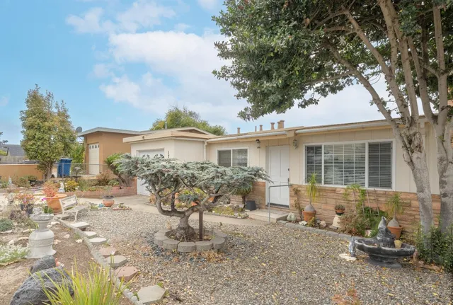 a front view of a house with a yard and seating space