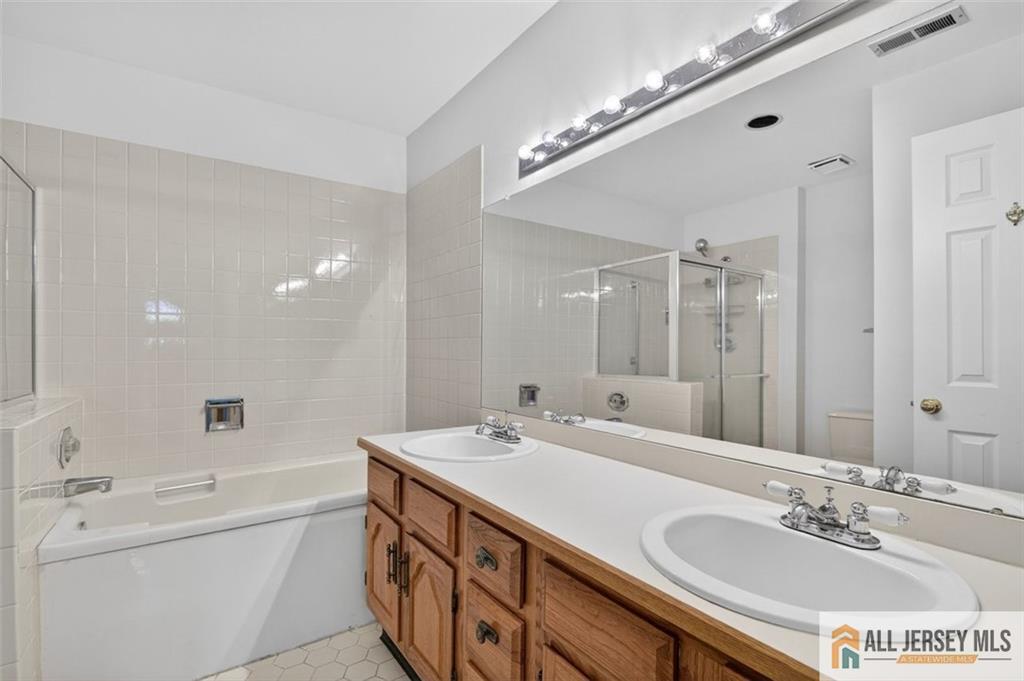 40C Rutland Lane, Unit 40B Monroe Township, NJ 08831 - Photo 24 of 37 a spacious bathroom with a double vanity sink a mirror and a bathtub