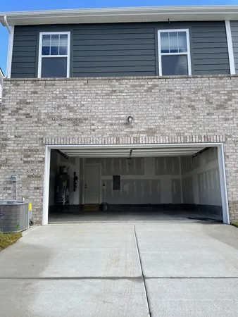 a view of a brick house with a large parking space in front of it