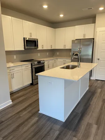 a kitchen with stainless steel appliances granite countertop a sink stove microwave and refrigerator