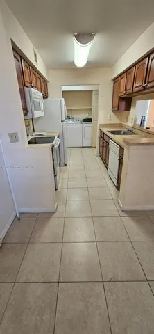 a view of a kitchen with refrigerator and sink