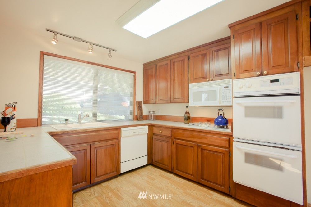 5558 West Mercer Way Mercer Island, WA 98040 - Photo 6 of 20 a kitchen with a sink a window and cabinets