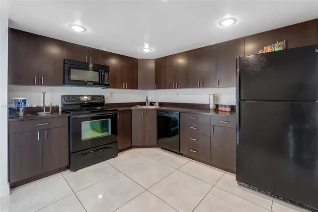 a kitchen with stainless steel appliances granite countertop a stove a refrigerator and a sink