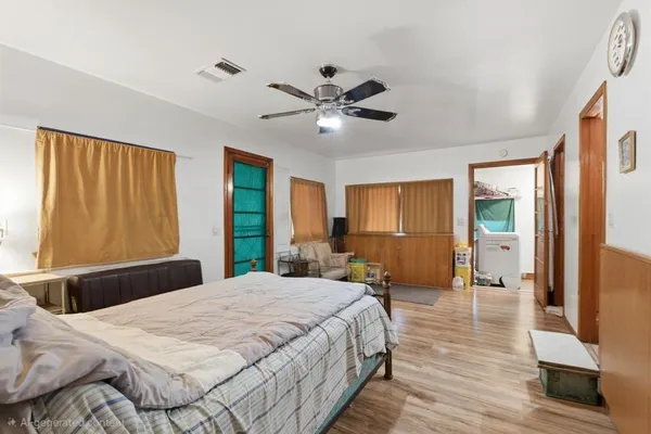 a bedroom with a large bed and a chandelier