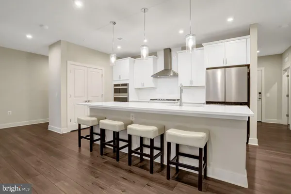 a kitchen with stainless steel appliances granite countertop a table chairs sink refrigerator and microwave