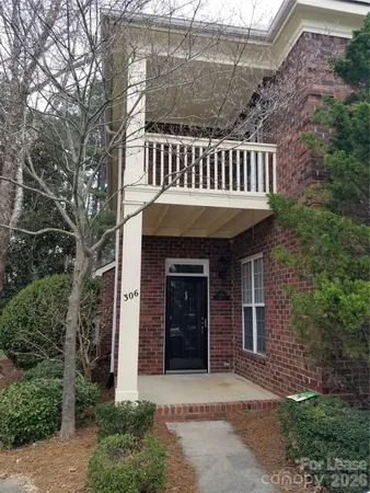 a view of a brick house with a small yard and plants