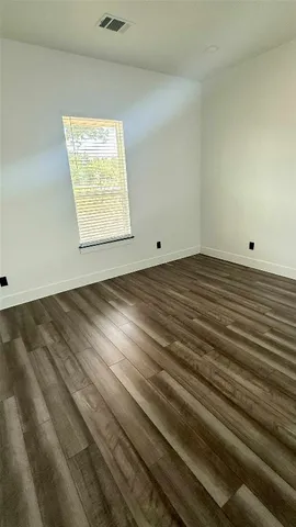 a view of a room with wooden floor and white walls