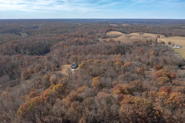 an aerial view of house with yard and mountain in the background