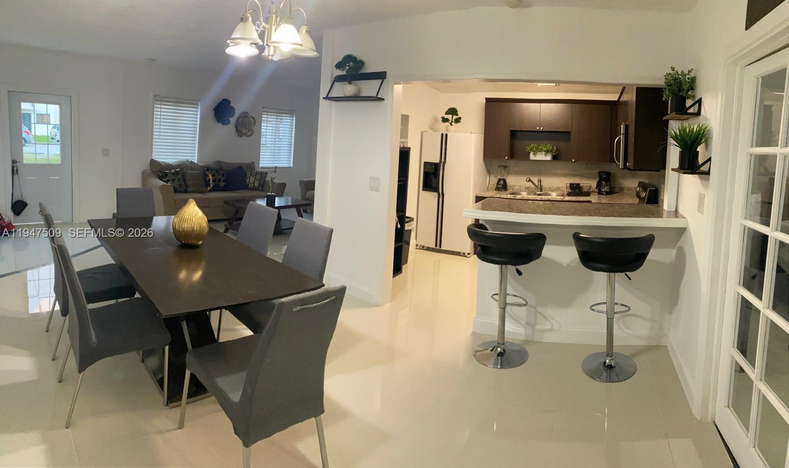3670 Southwest 12th Street, Unit 1 Miami, FL 33135 - Photo 4 of 5 a view of a dining room with furniture and a chandelier