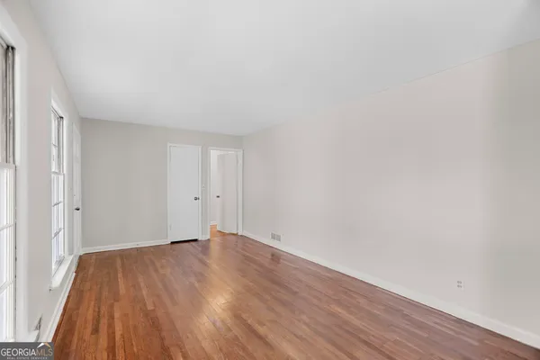 a view of an empty room with wooden floor