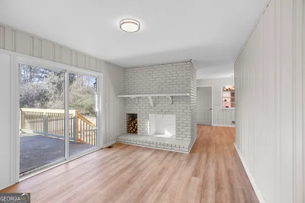 a view of empty room with wooden floor and fireplace