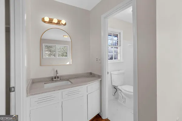 a bathroom with a toilet a sink and mirror