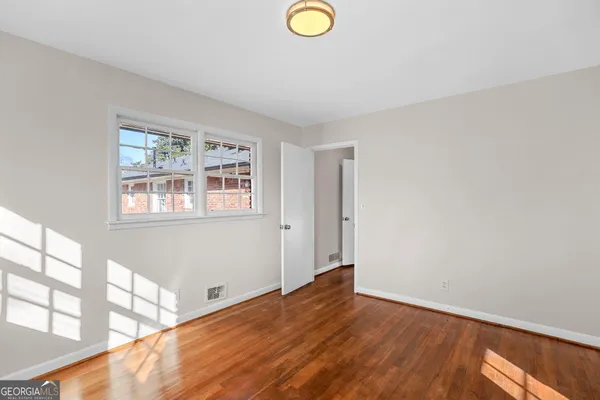 a view of empty room with wooden floor