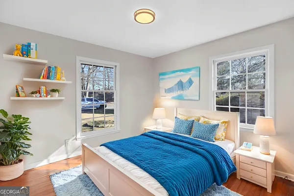 a bedroom with a bed and a potted plant next to a window