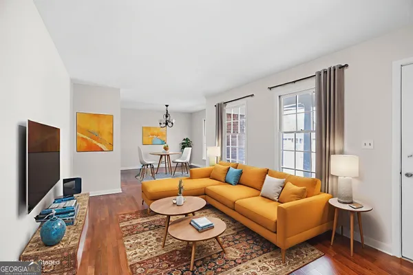 a living room with furniture a flat screen tv and a window