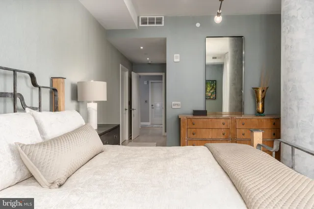 a bedroom with a bed and mirror