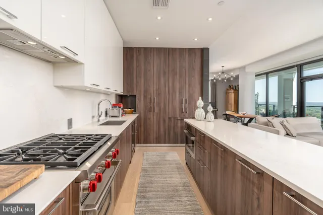 a kitchen with kitchen island granite countertop a sink stove and cabinets