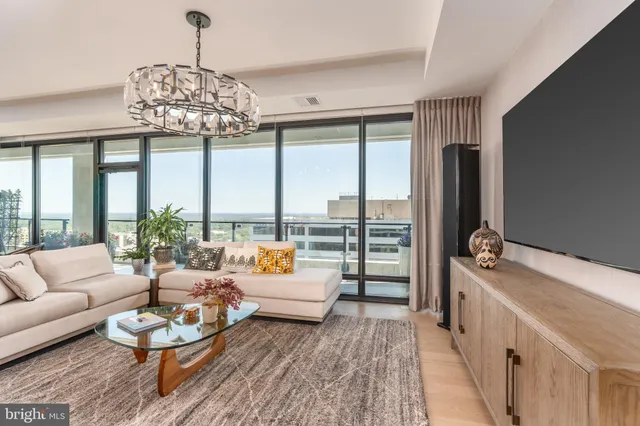 a living room with furniture and a chandelier