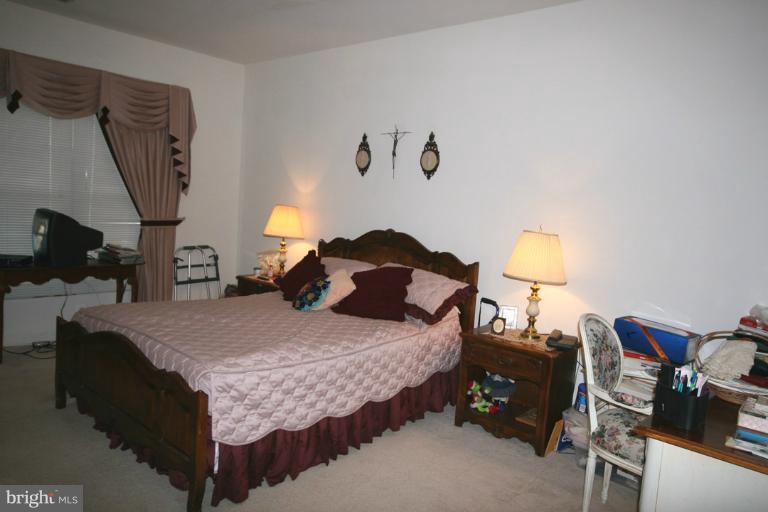 333 Colony Point Place Edgewater, MD 21037 - Photo 5 of 11 a bedroom with a bed and a lamp on table