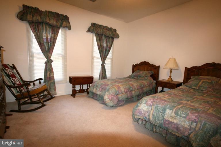 333 Colony Point Place Edgewater, MD 21037 - Photo 9 of 11 a bedroom with two beds and a chandelier