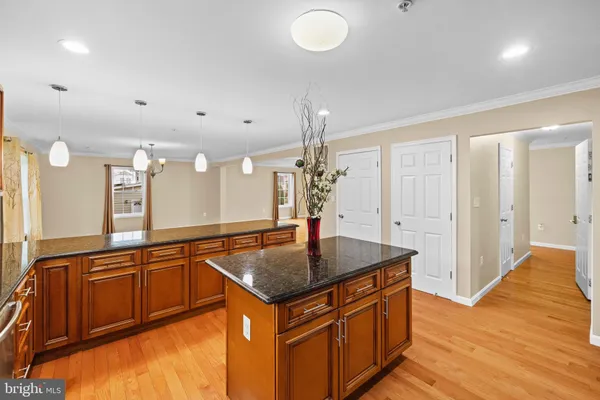 a kitchen with stainless steel appliances granite countertop a sink and a wooden floor
