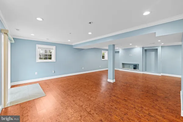 a view of an empty room with window and wooden floor