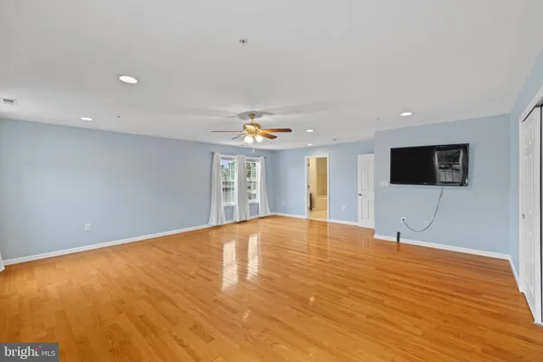 an empty room with a window and a fan
