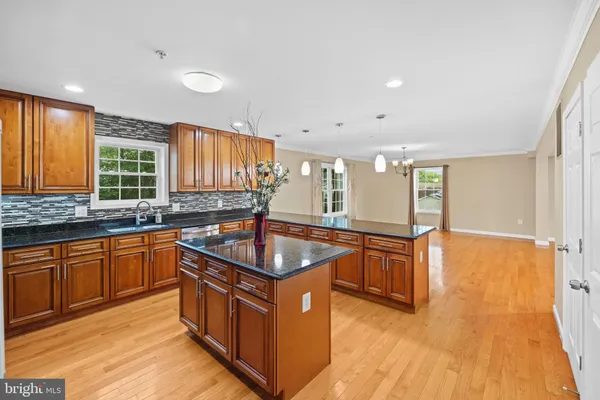 a kitchen with stainless steel appliances granite countertop a sink a stove a counter space and cabinets