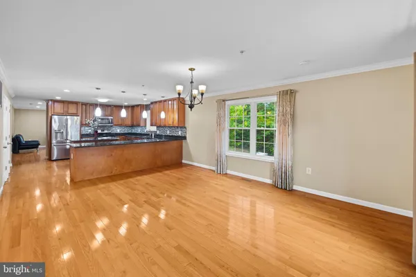 a view of a kitchen with kitchen island a sink wooden floor and a counter top space
