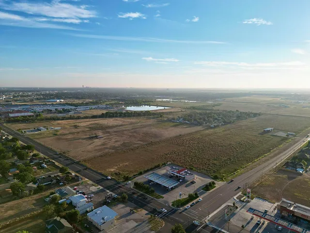 an aerial view of ocean and residential houses with outdoor space